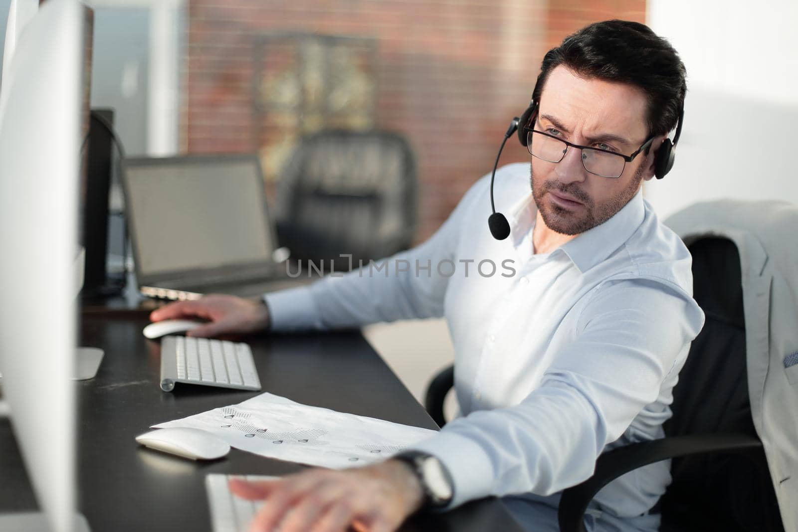 close up.businessman with a headset sitting at his Desk.people and technology