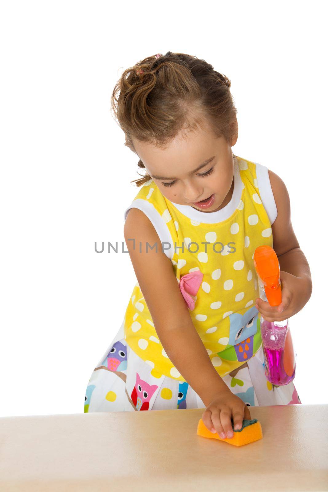Diligent little girl puts things in order on the table. Girl rubbing with a sponge or a gel to the surface of the table . Close-up - Isolated on white background