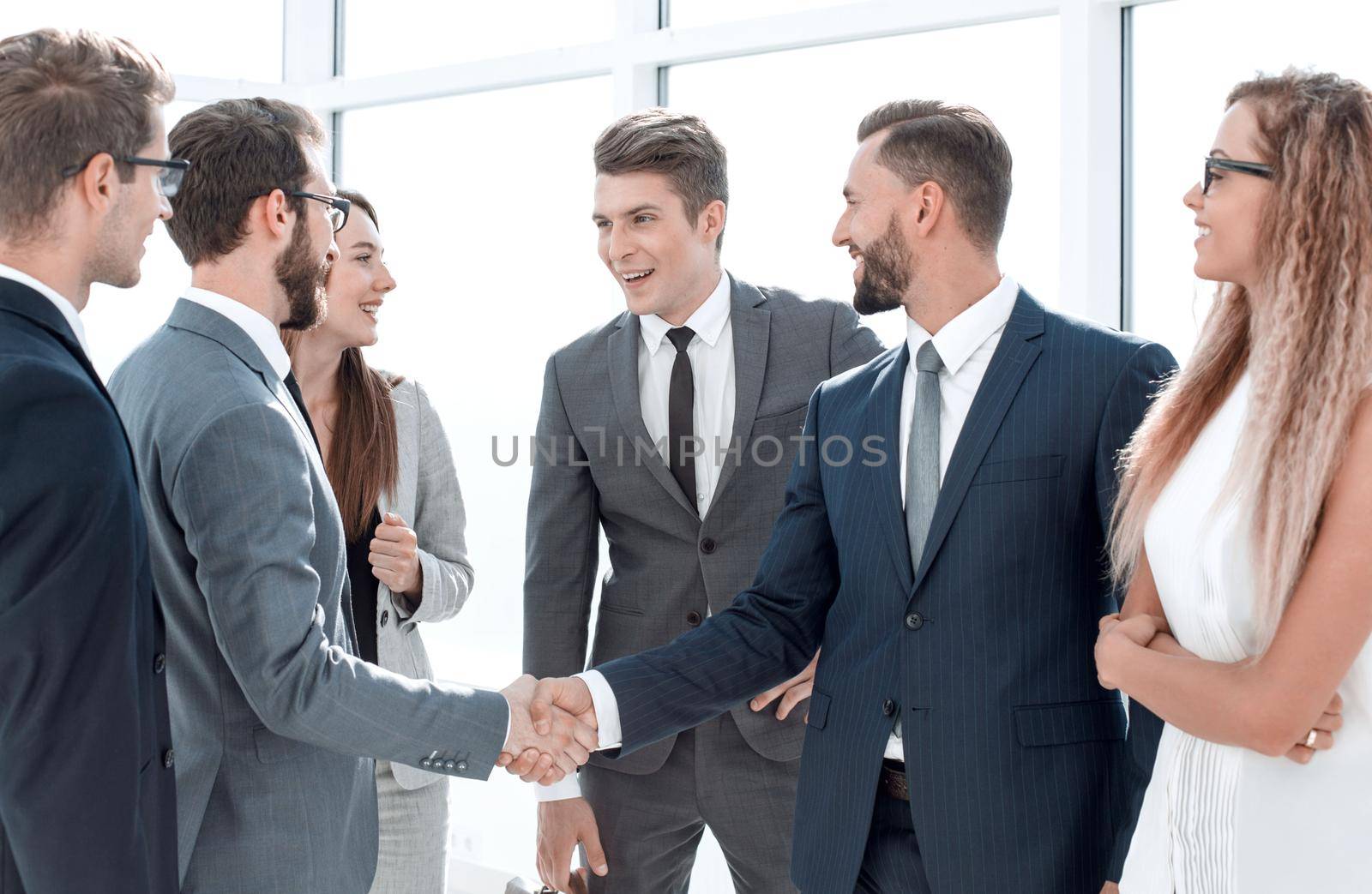 employees greet each other with a handshake by asdf