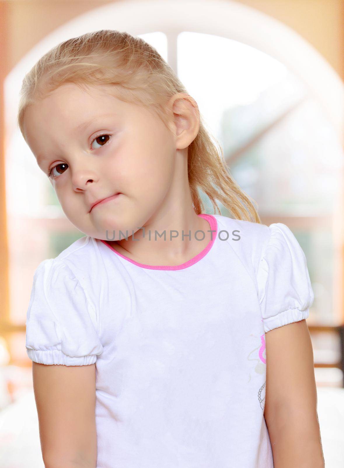 Delicate little blonde girl in a white t-shirt.