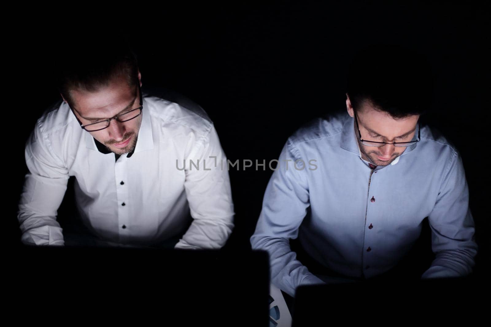 close up.two colleagues working on computers.isolated on black