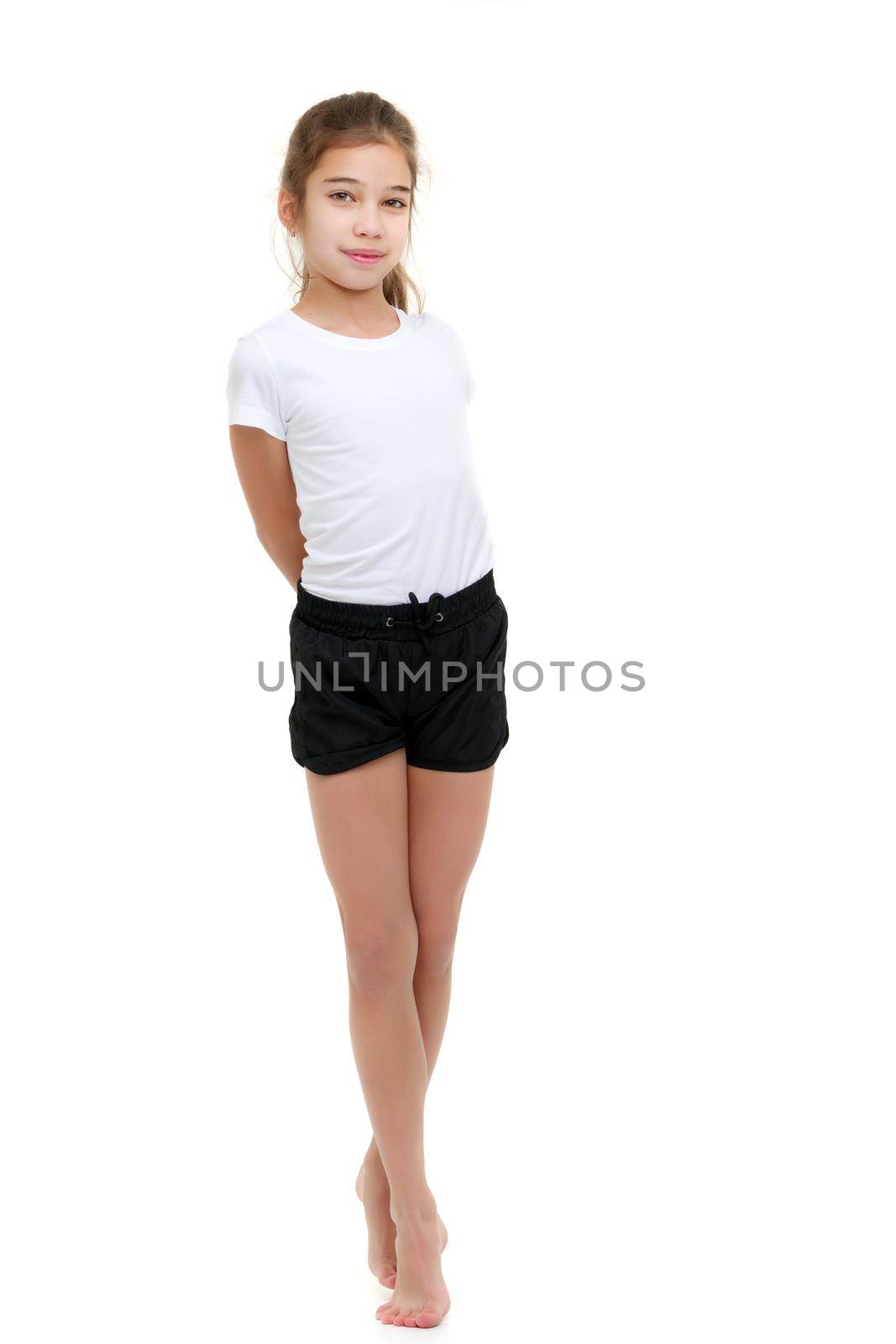 Beautiful little girl in short shorts and a pure white T-shirt on which you can make any inscription. The concept of advertising, including children's products. In full growth. Isolated on white background.