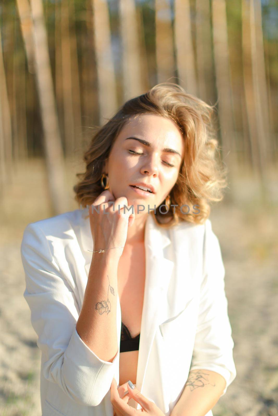 Portrait of young woman wearing white shirt and black bra in sand beach bachground.