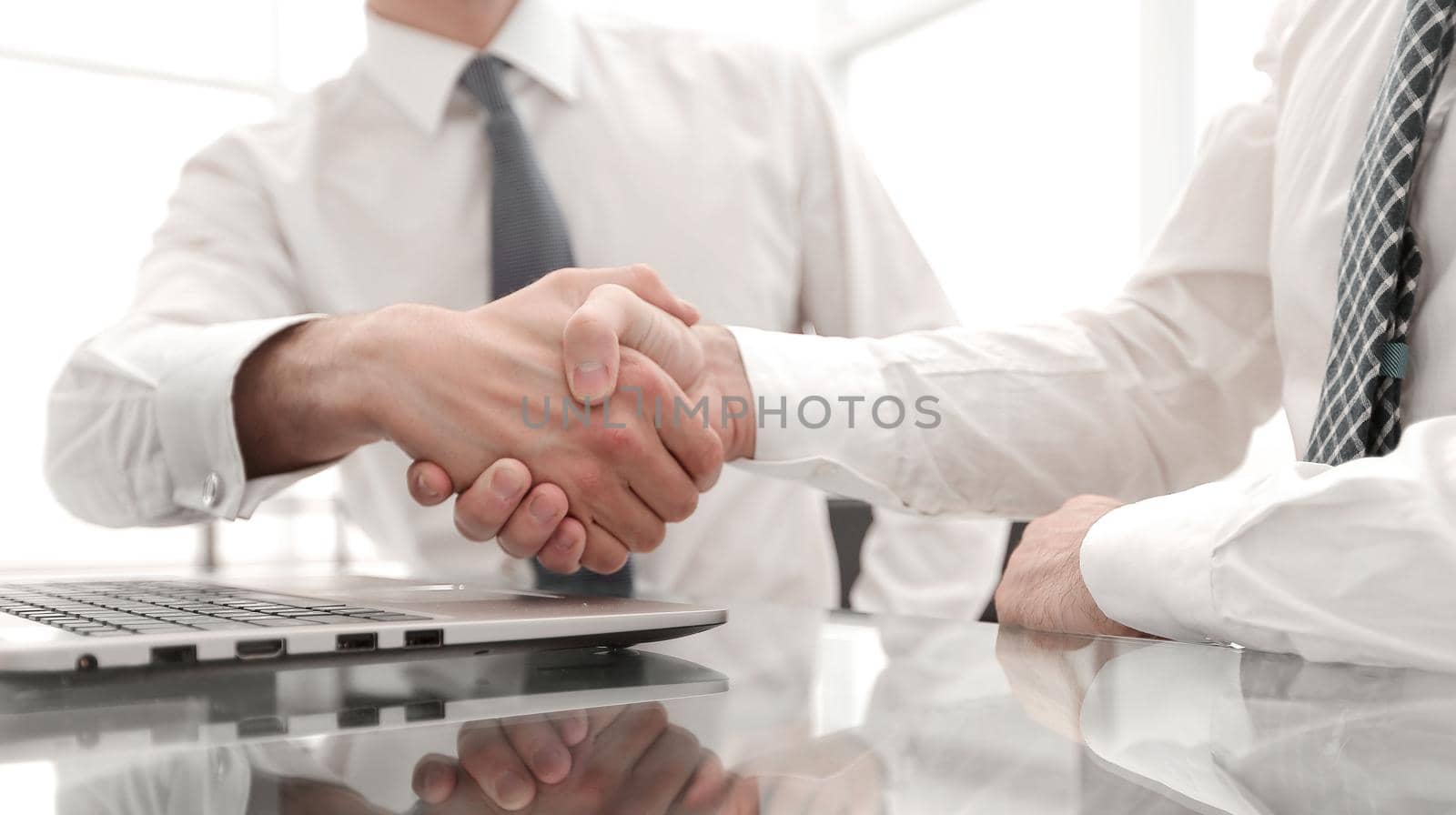 close up.colleagues shaking hands over a Desk .photo with copy space