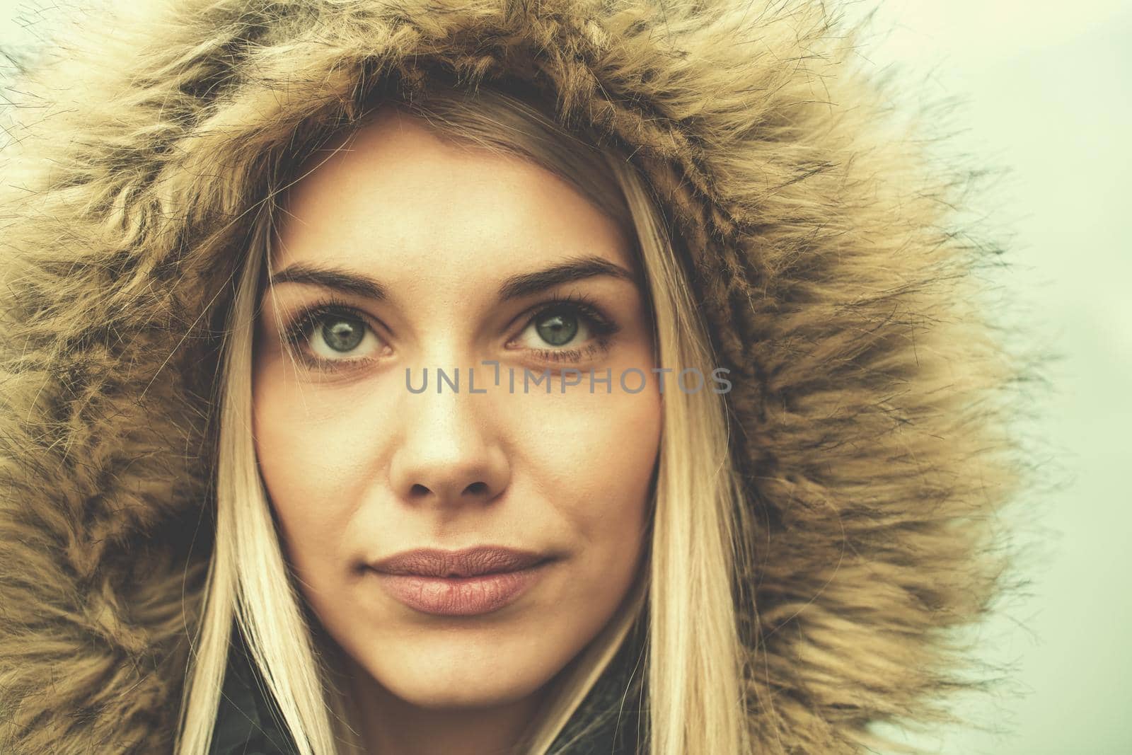portrait of young blonde girl wearing winter jacket by dotshock