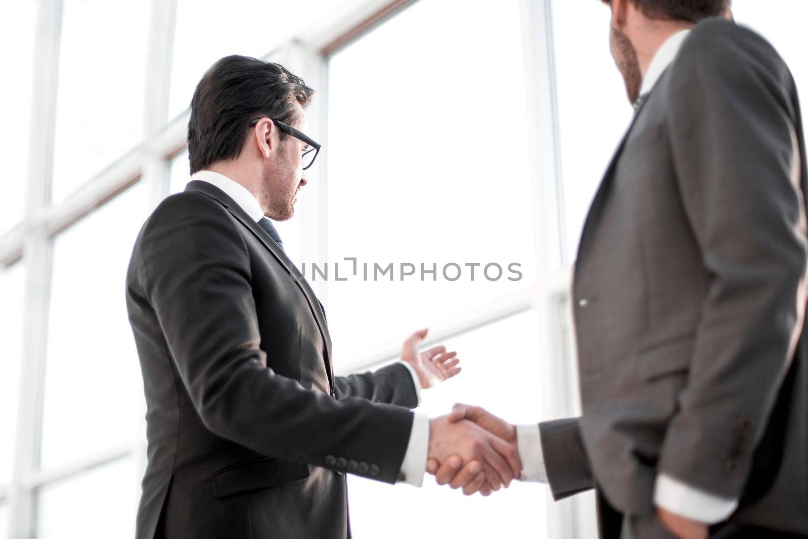 close up. businessmen shaking hands during a conversation in the office by asdf