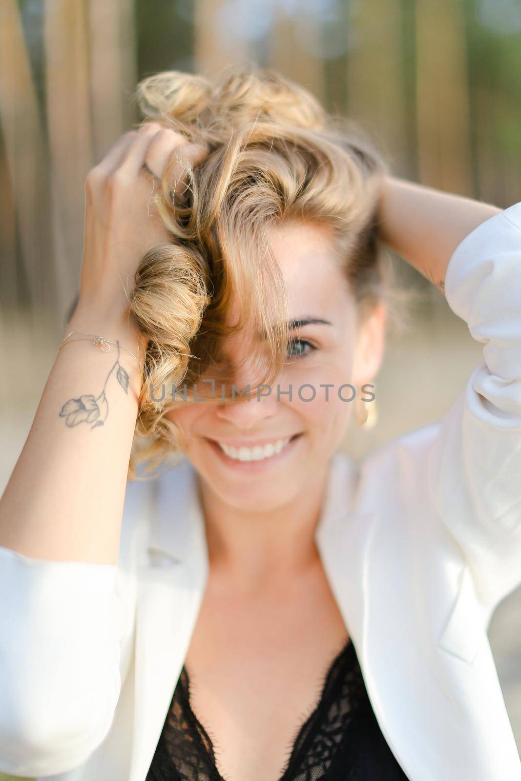 Portraint of young ute woman with little hand tattoo wearing white shirt and black bra. by sisterspro