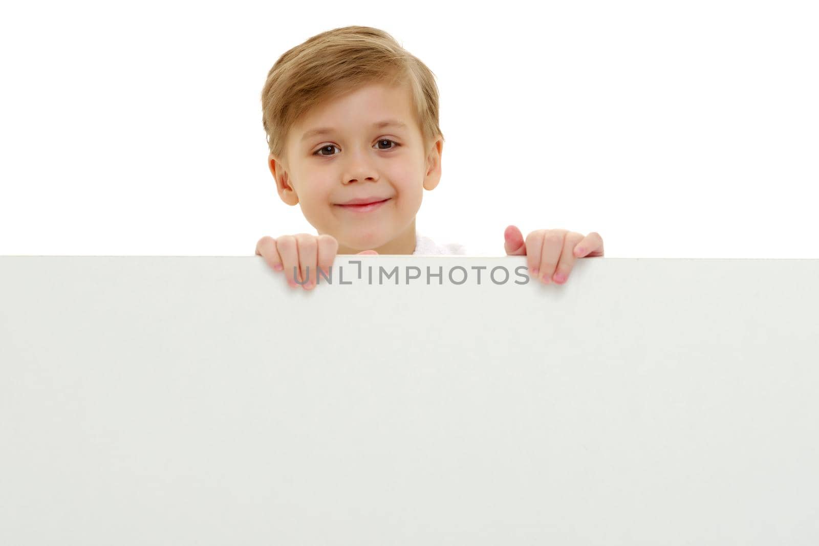 A little boy is looking from behind an empty banner. by kolesnikov_studio