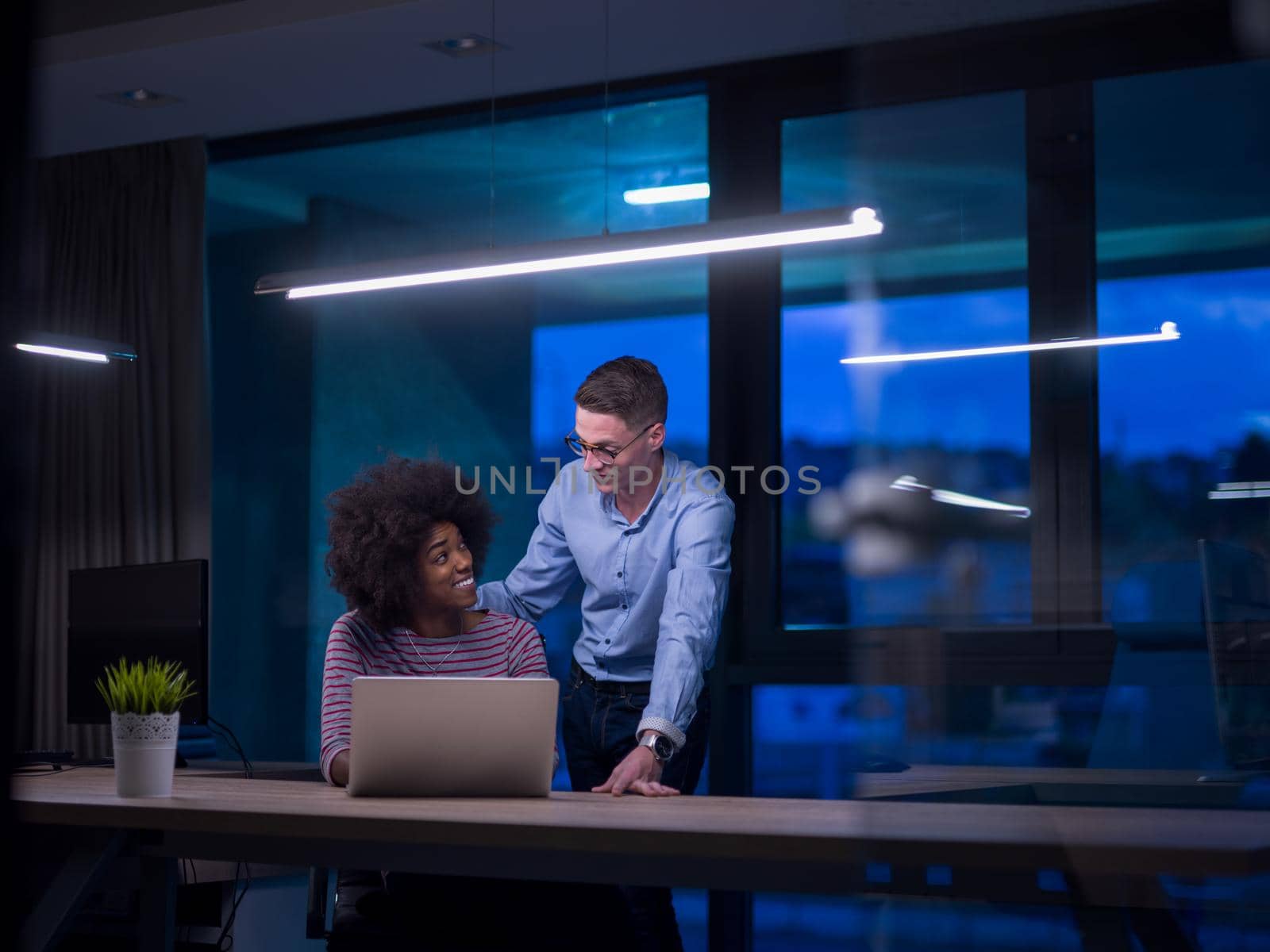 Multiethnic startup business team in night office by dotshock