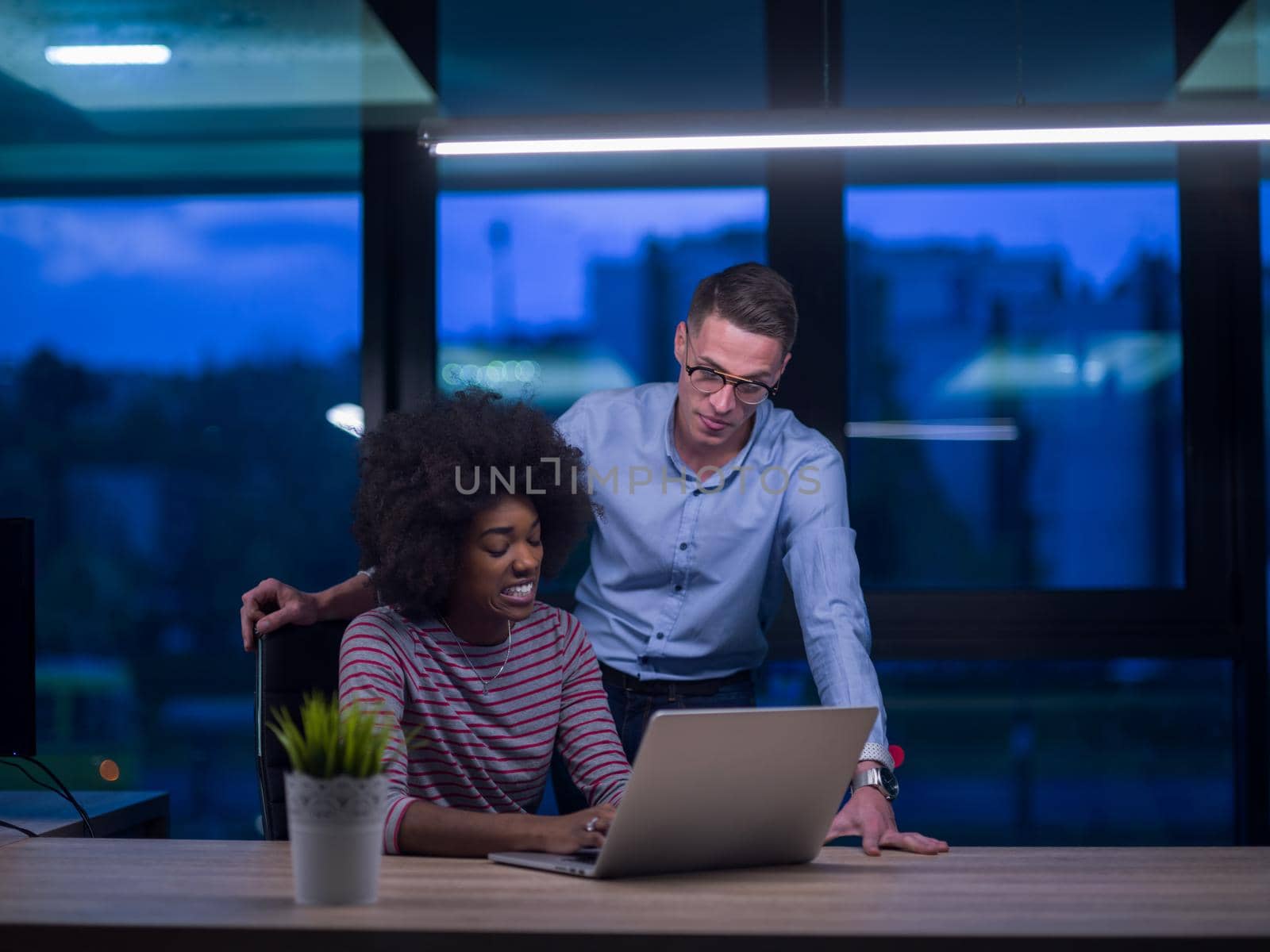 Multiethnic startup business team in night office by dotshock