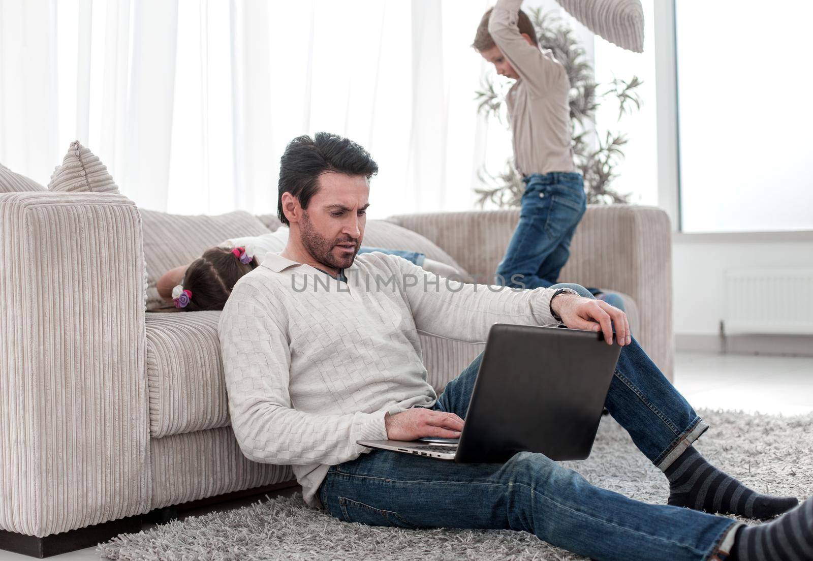 man with a laptop sitting in the living room by asdf