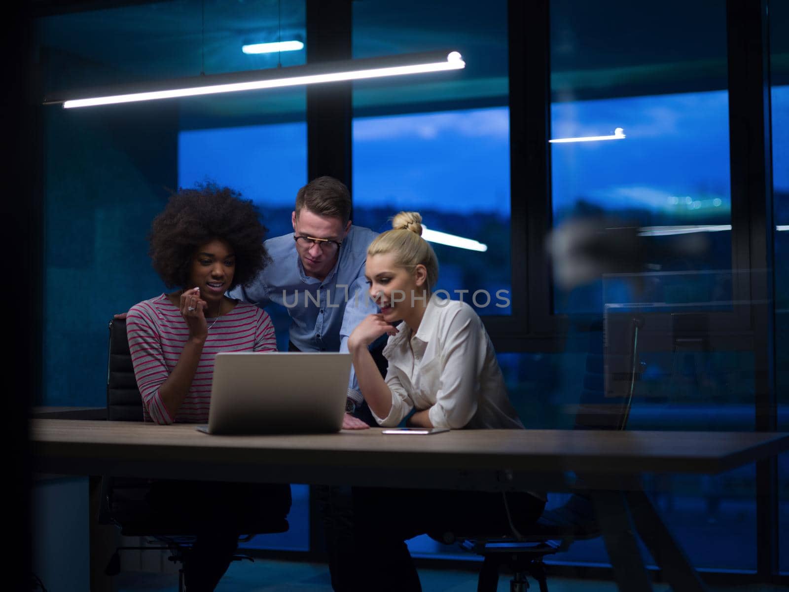 Multiethnic startup business team in night office by dotshock