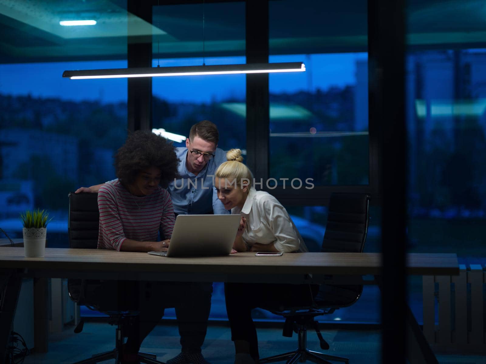 Multiethnic startup business team in night office by dotshock