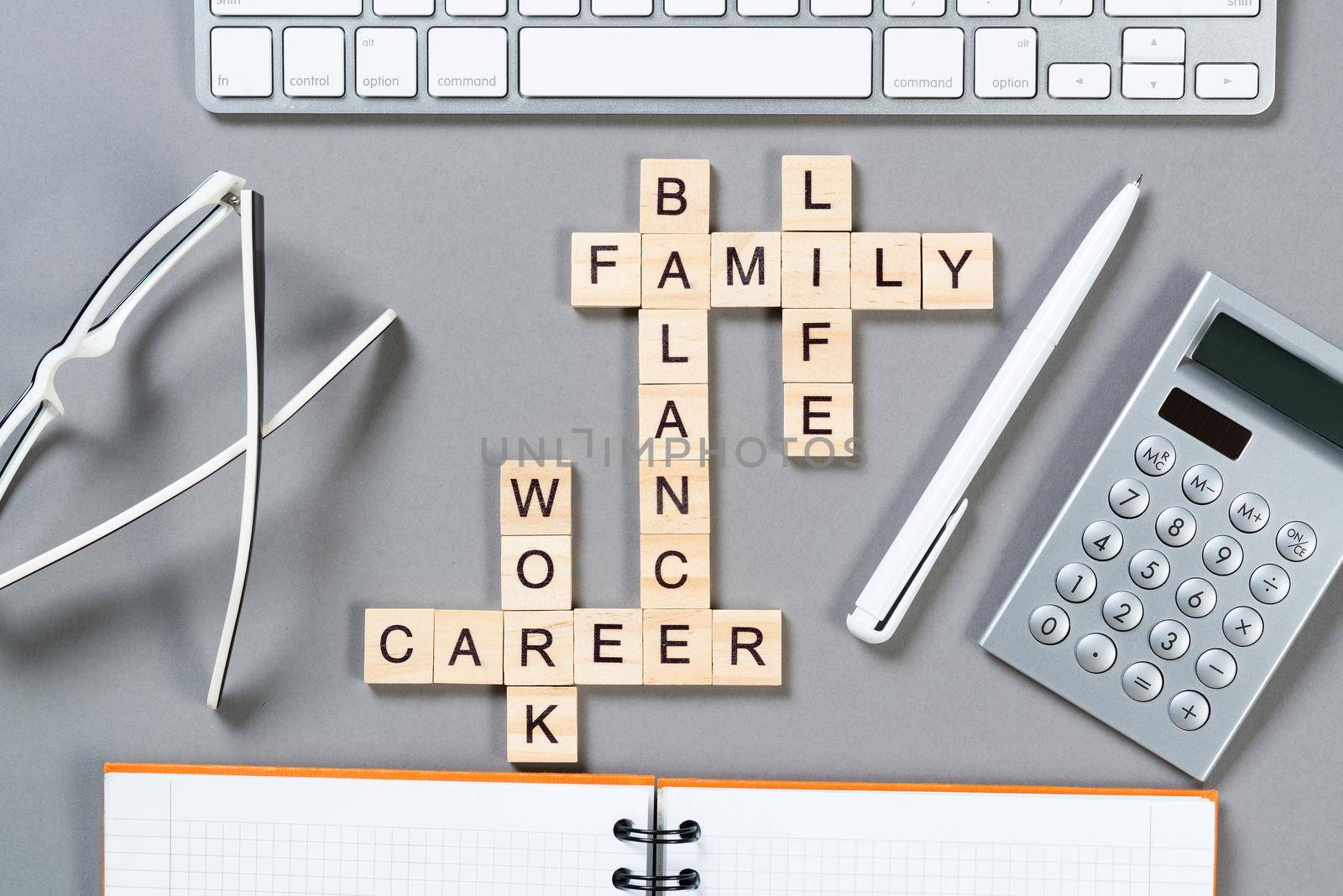 Business motivation concept with words from cubes. Still life of office workplace with crossword. Flat lay grey surface with computer keyboard and calculator. Strategy planning and business analytics.