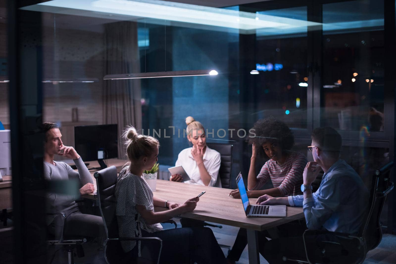 Multiethnic startup business team in night office by dotshock