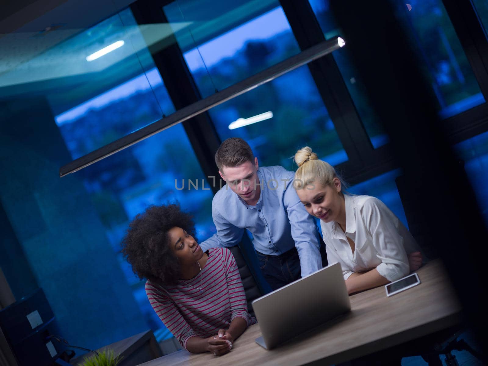 Multiethnic startup business team in night office by dotshock