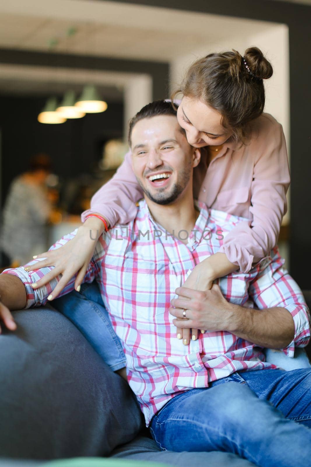 Young wife kissing and hugging husband at home. Concept of spending time together, relationship and love.