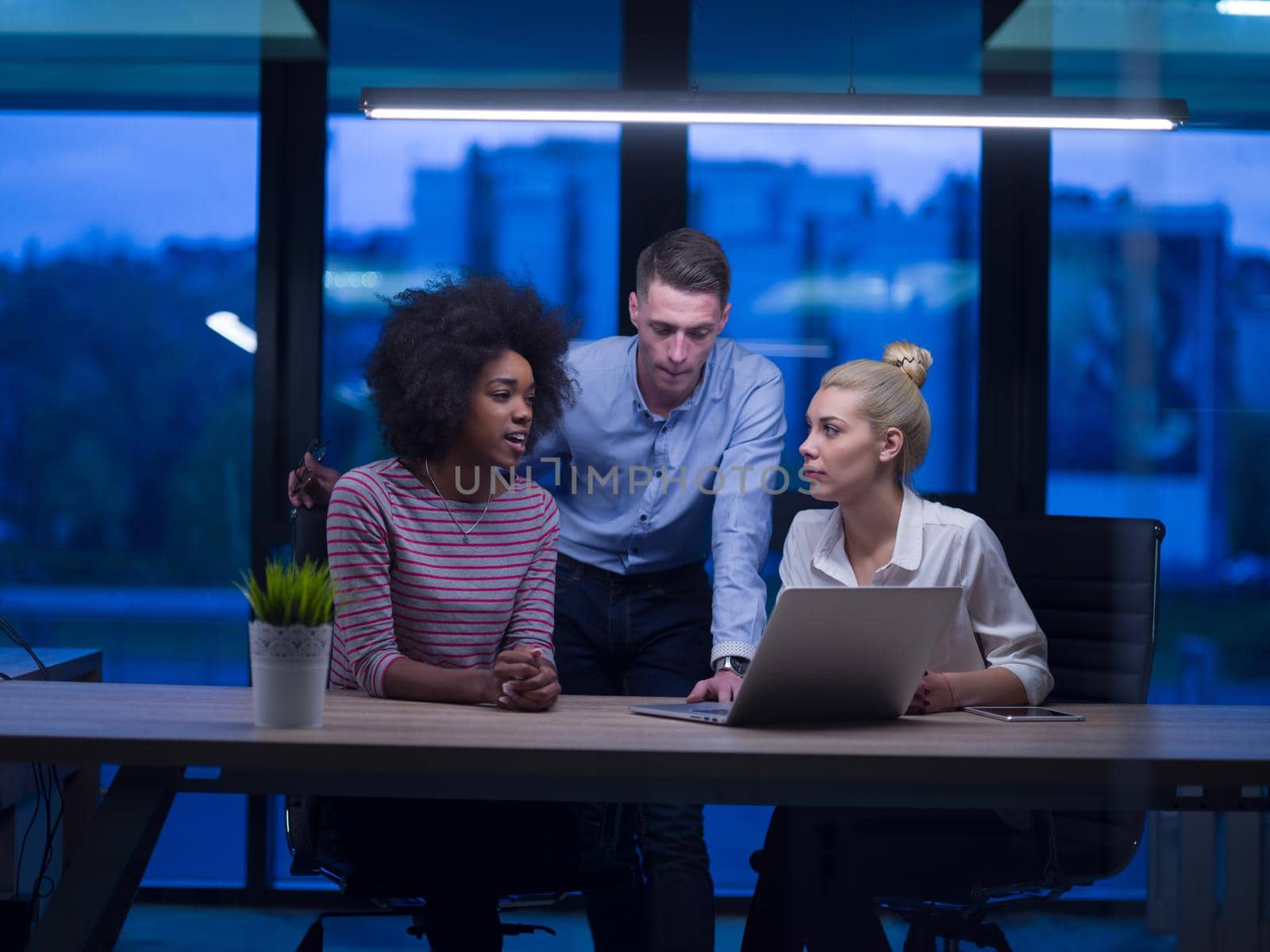 Multiethnic startup business team in night office by dotshock