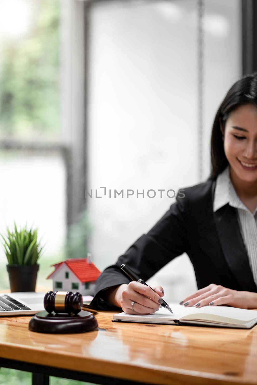 Close up business woman and lawyers discussing contract papers with brass scale on wooden desk in office. Law, legal services, advice, Justice and real estate concept. by nateemee