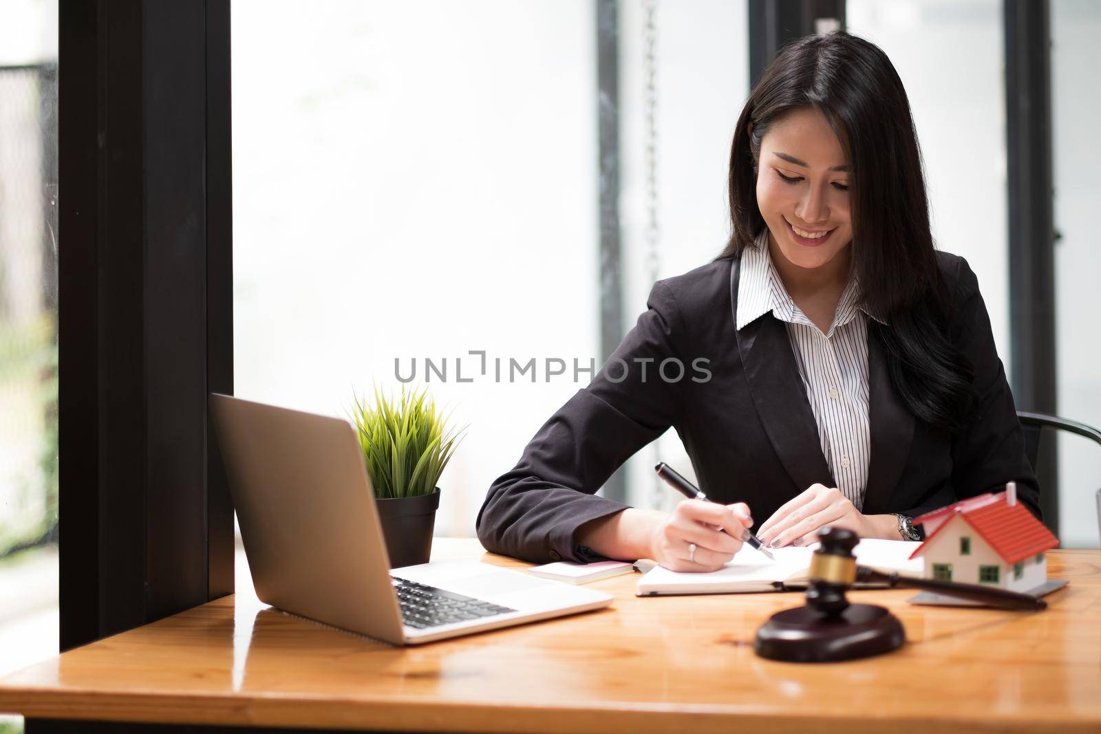 Close up business woman and lawyers discussing contract papers with brass scale on wooden desk in office. Law, legal services, advice, Justice and real estate concept. by nateemee