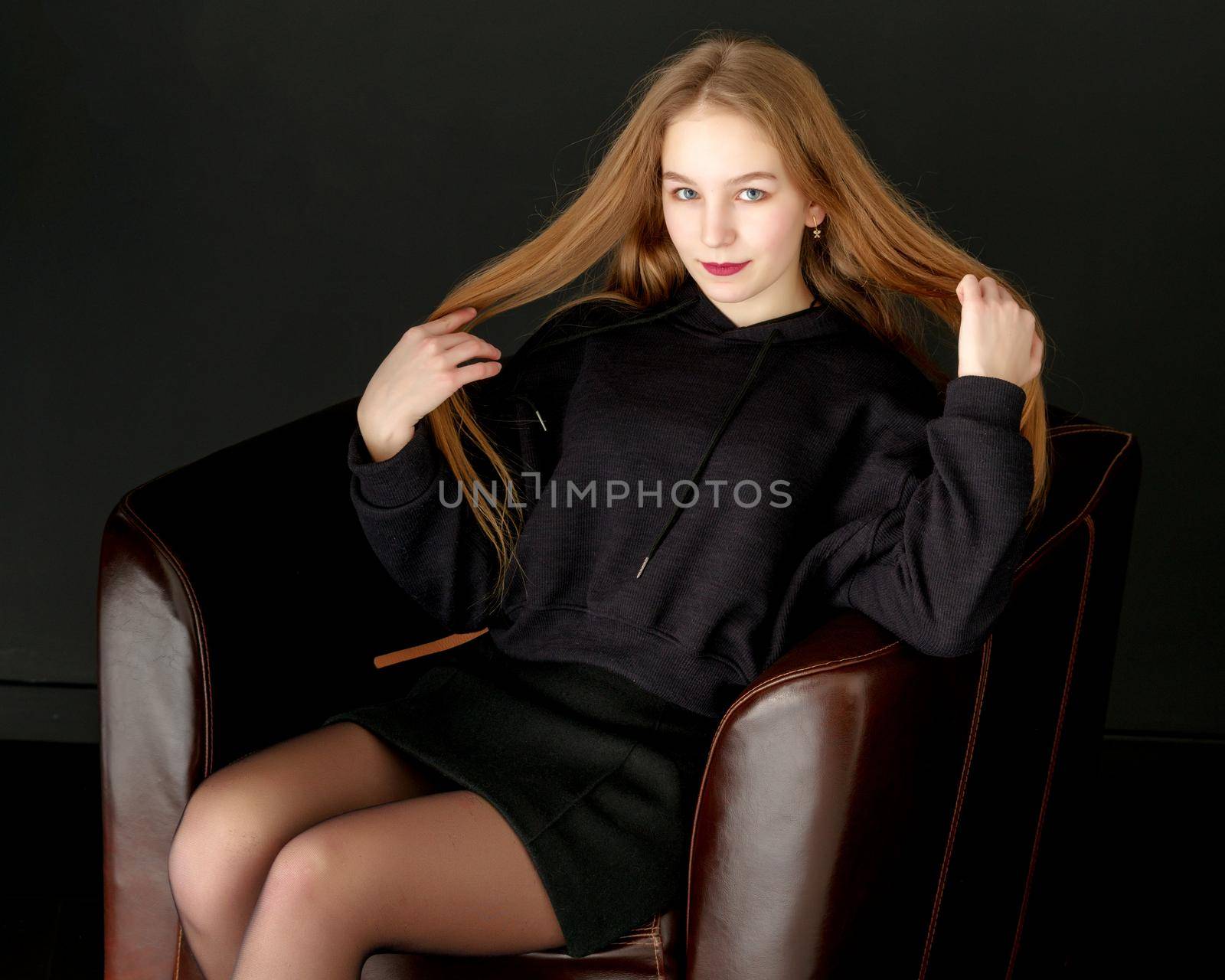 Fashionable girl teenager studio photo on a black background. by kolesnikov_studio