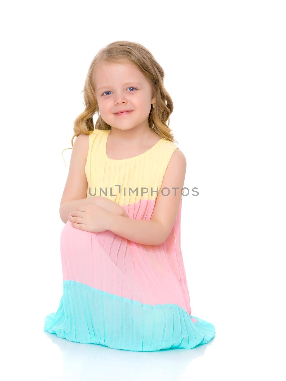 Little girl is sitting on the floor. The concept of a happy childhood. Isolated on white background.