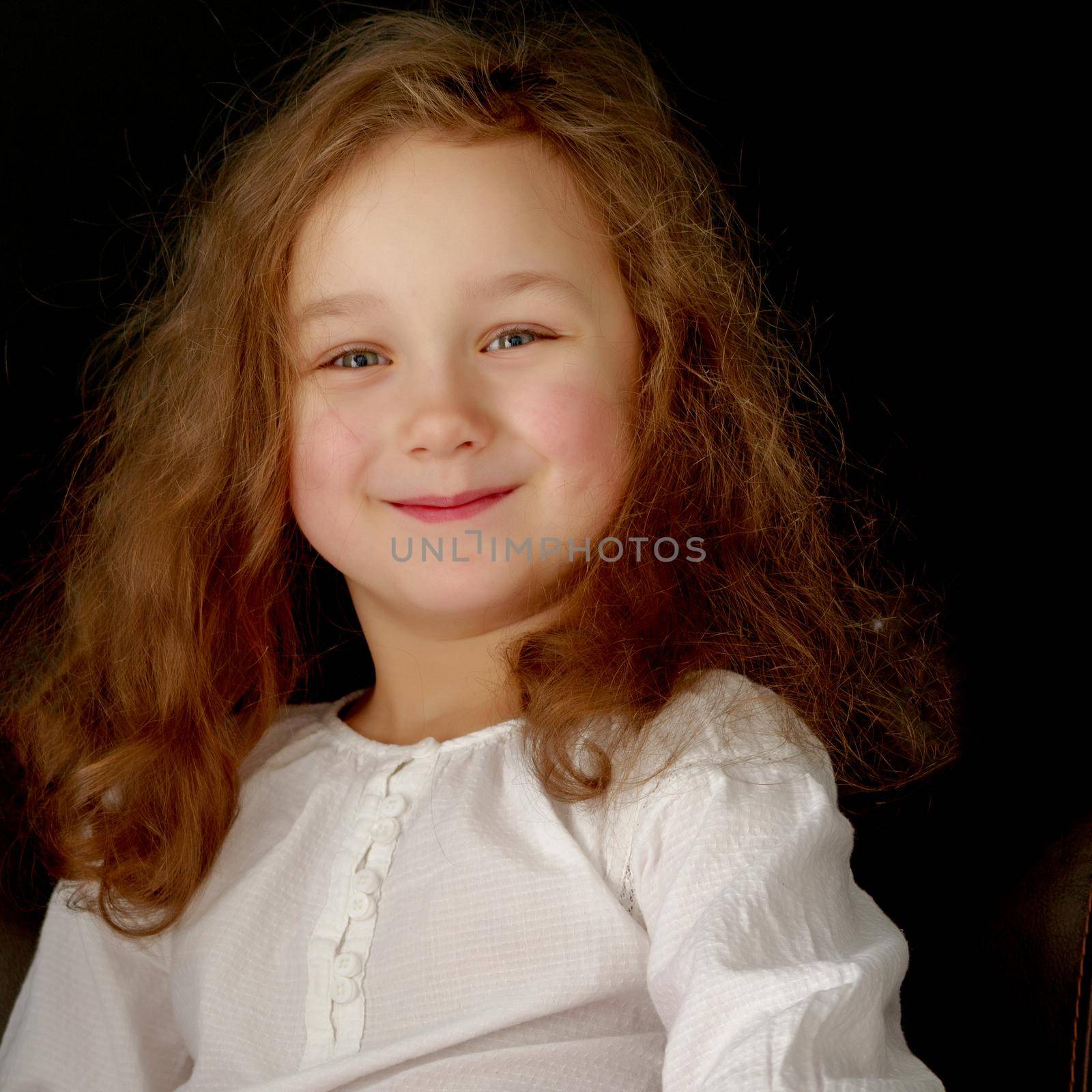 Beautiful little girl on a black background. Studio photography