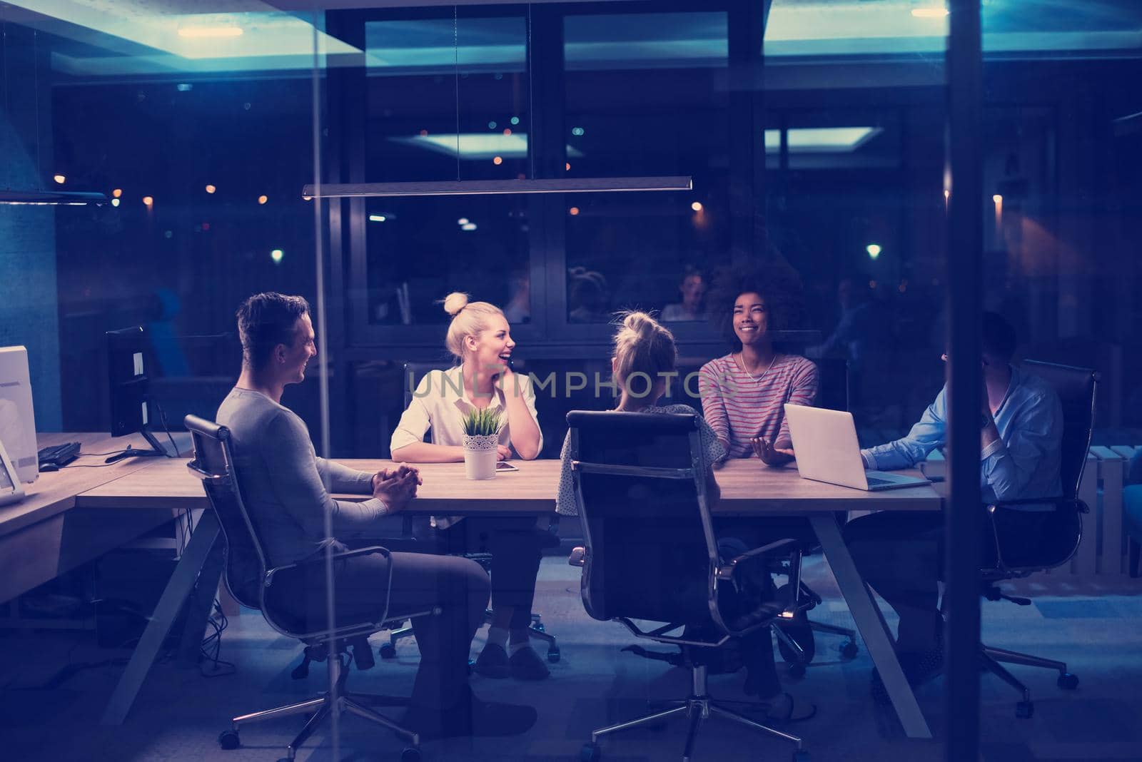 Multiethnic startup business team in night office by dotshock