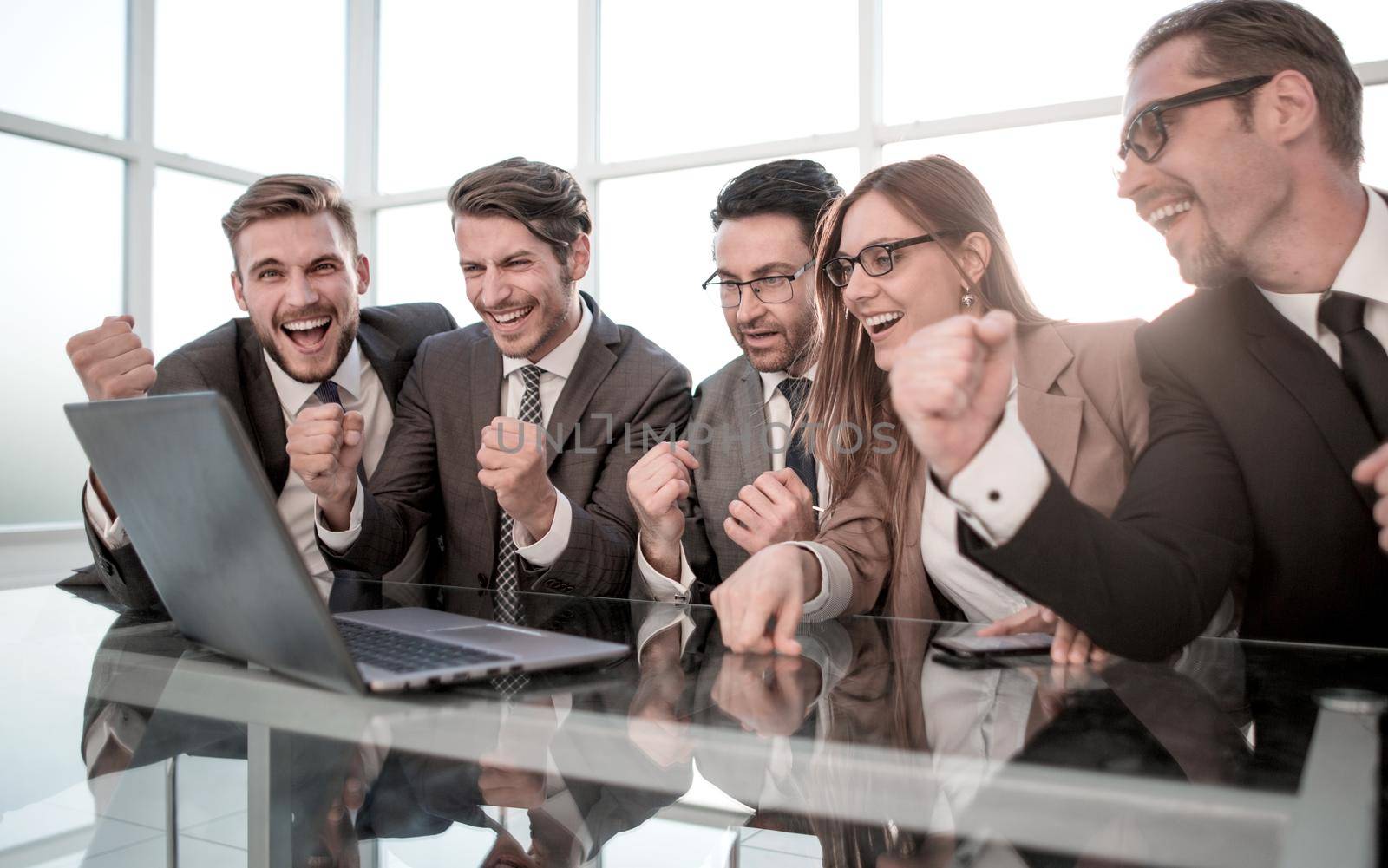 Happy young businesspeople in suit looking at laptop, excited by good news on internet