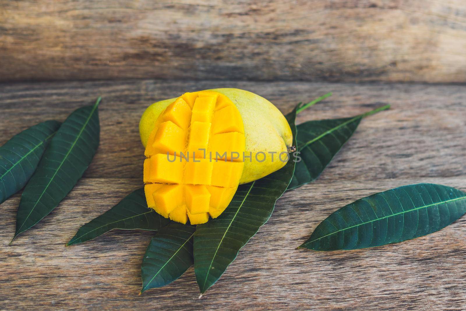 Mango and mango leaves on an old wooden background.
