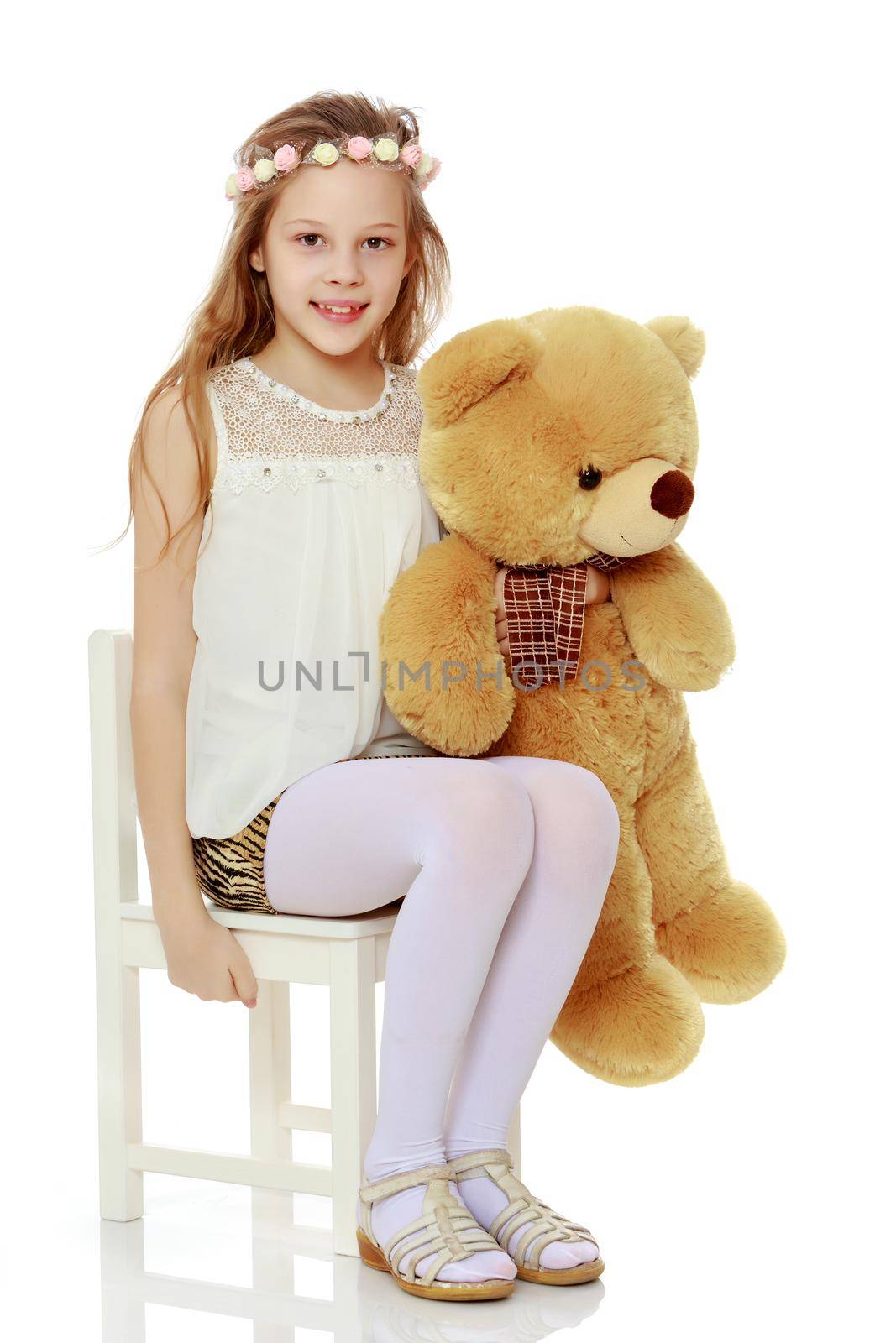 Little girl with a teddy bear. The concept of the game, raising a child in kindergarten and in the family. Isolated on white background.