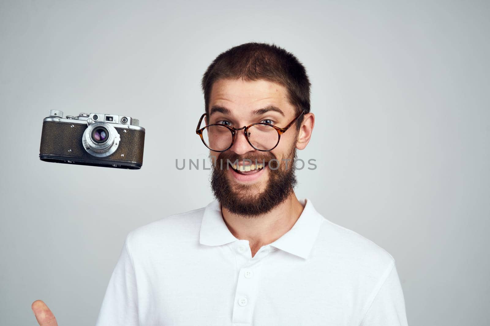 Cheerful man with a camera in his hands. Professional fashion lifestyle. High quality photo