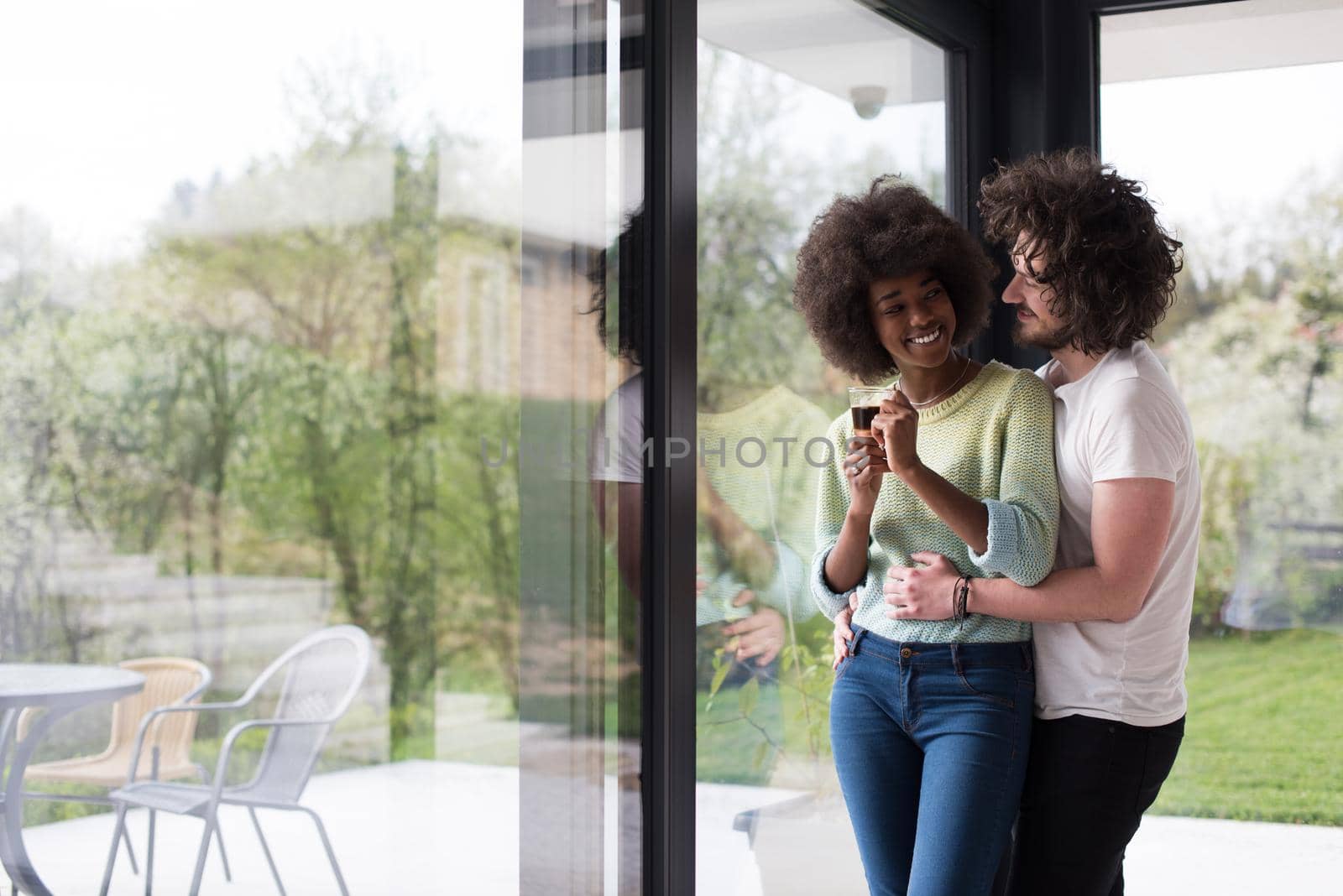happy multiethnic couple relaxing at modern home indoors by dotshock