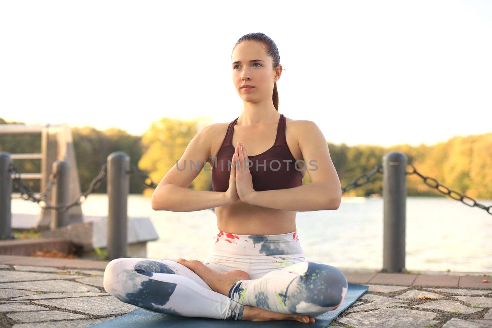 Young pretty woman doing yoga exercises in the park