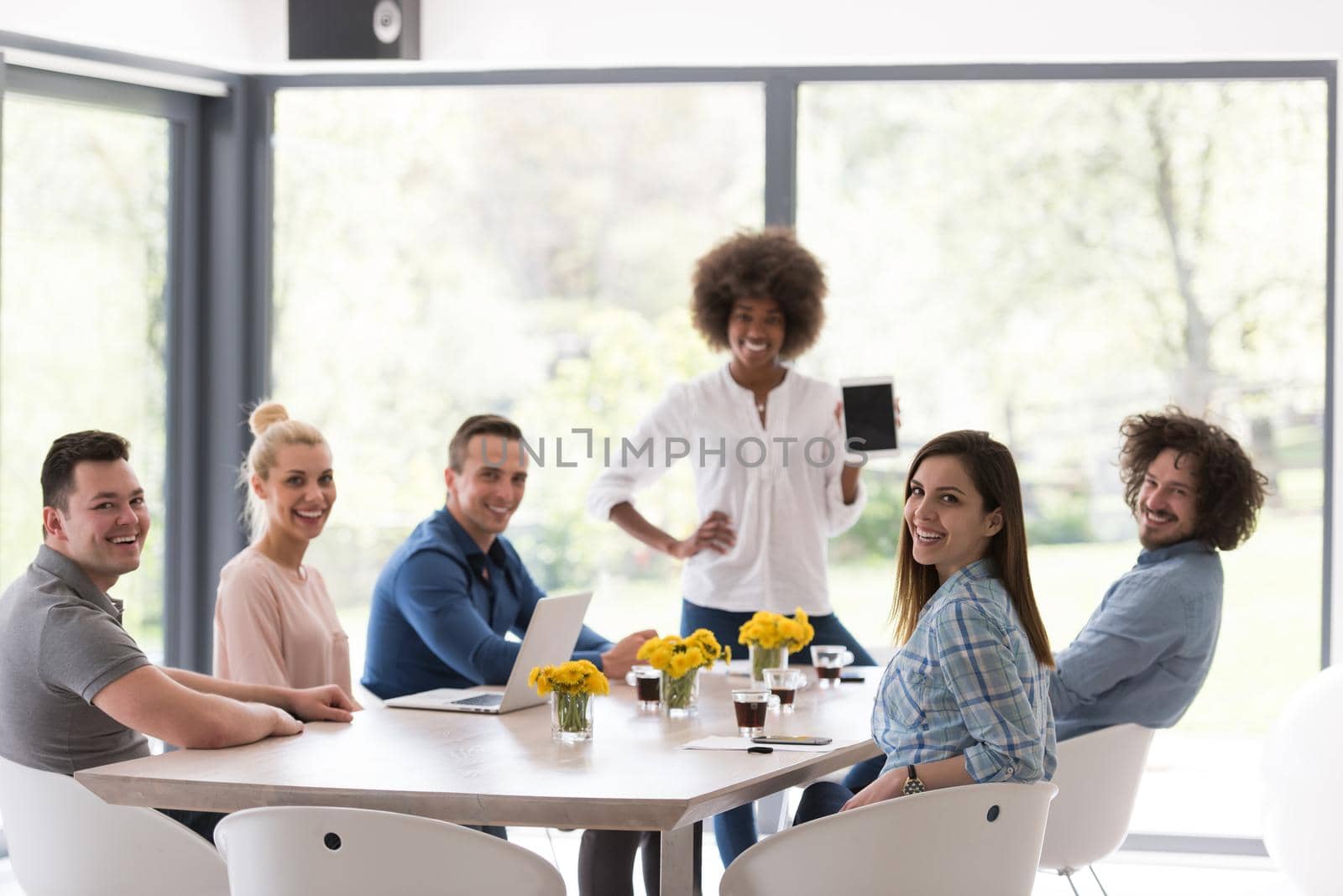 Multiethnic startup business team on meeting in modern bright office interior brainstorming, working on laptop and tablet computer