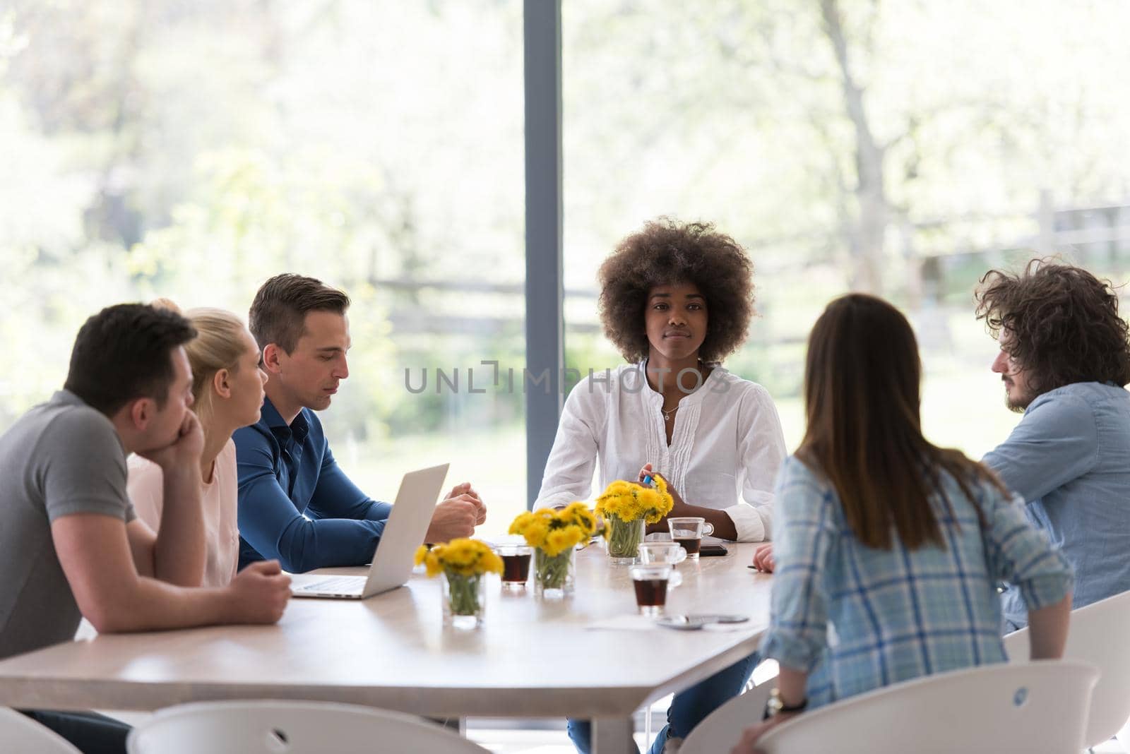 Multiethnic startup business team on meeting in modern bright office interior brainstorming, working on laptop and tablet computer