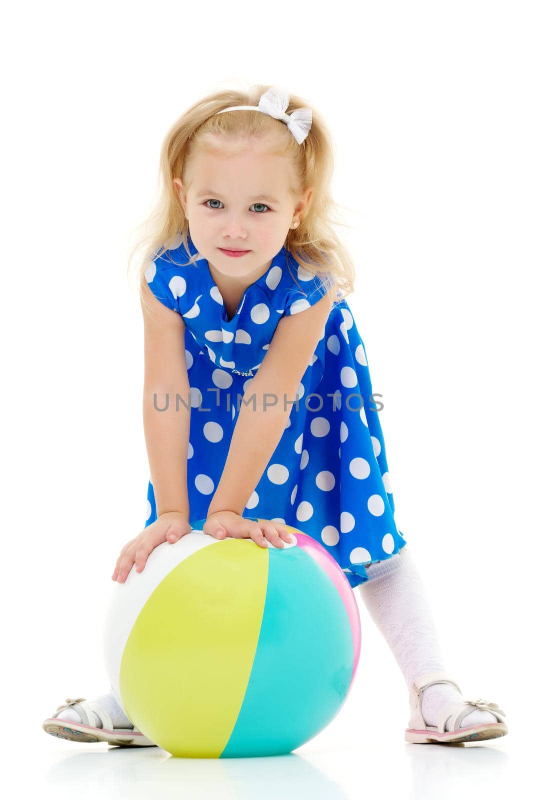 A good girl is playing with a big inflatable ball. The concept of a happy childhood, recreation in nature, exercise. Isolated on white background.