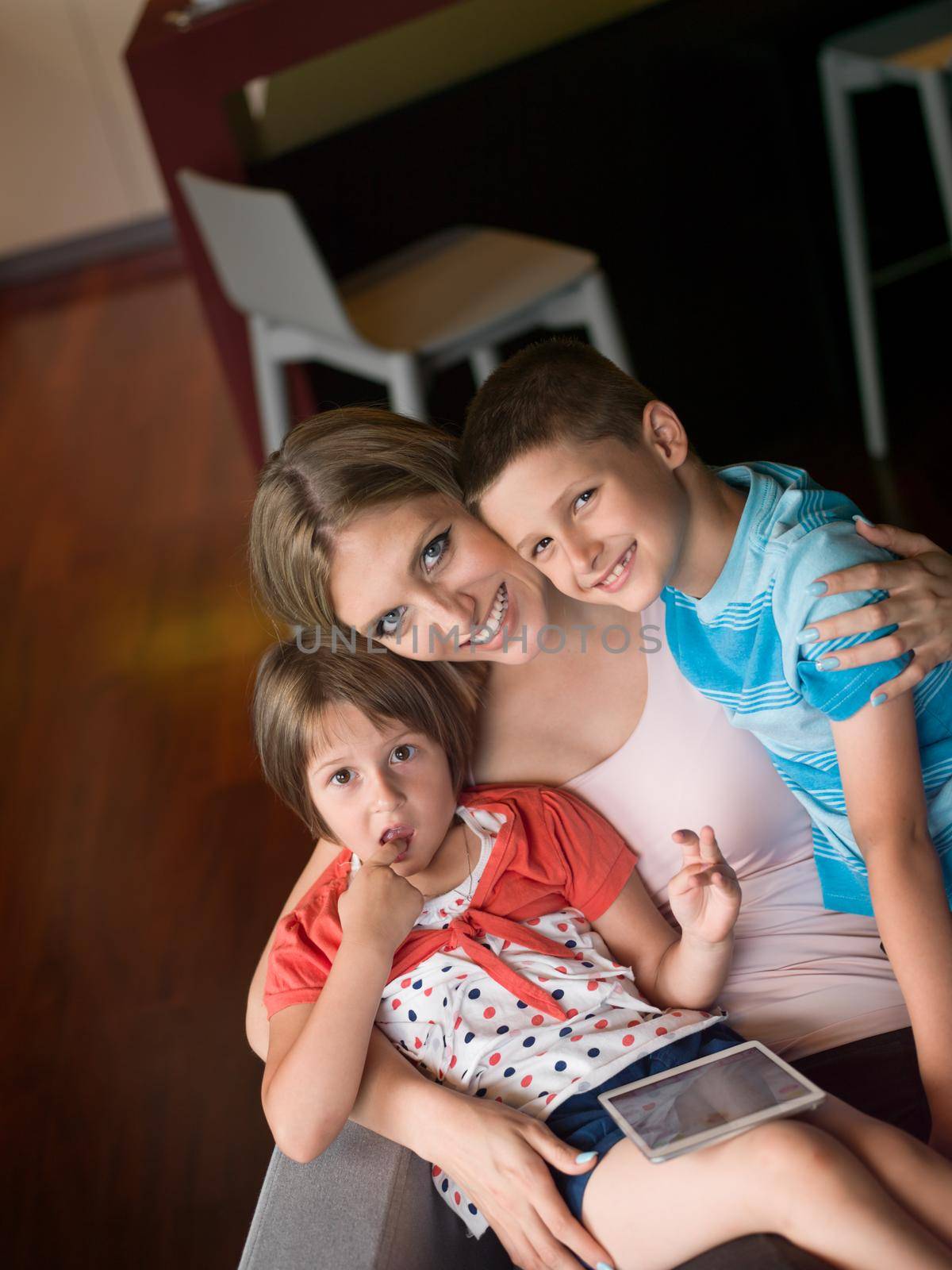 Happy Family Lying Down On The Sofa And Using Tablet