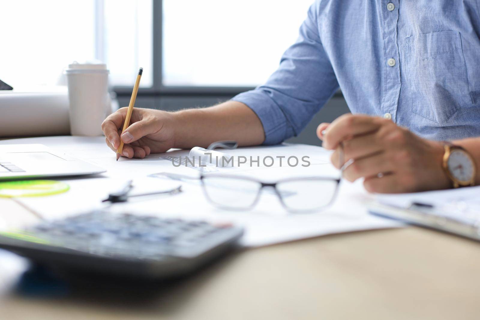 Shot of architect's hands drawing with pencil while working in the creative working space