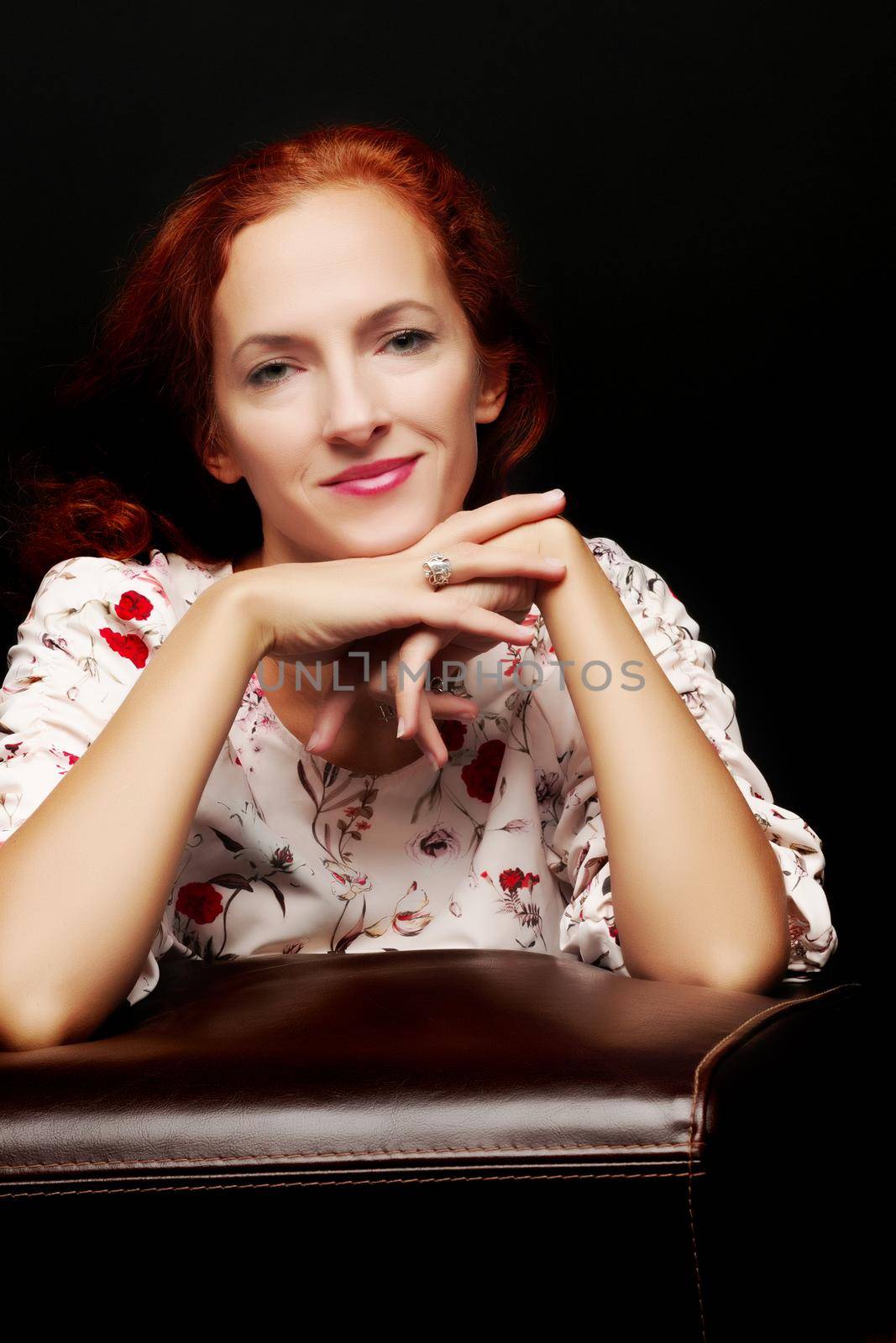 Red-haired young woman in the studio on a black background. by kolesnikov_studio