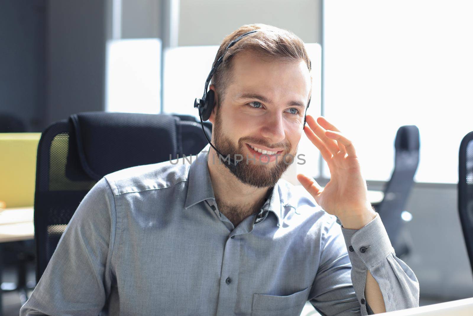 Smiling friendly handsome young male call centre operator. by tsyhun