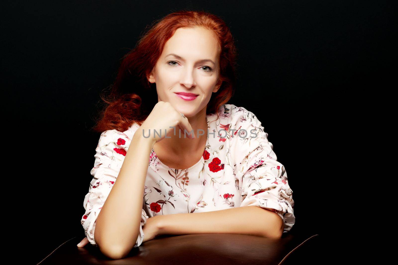 Red-haired young woman in the studio on a black background. by kolesnikov_studio