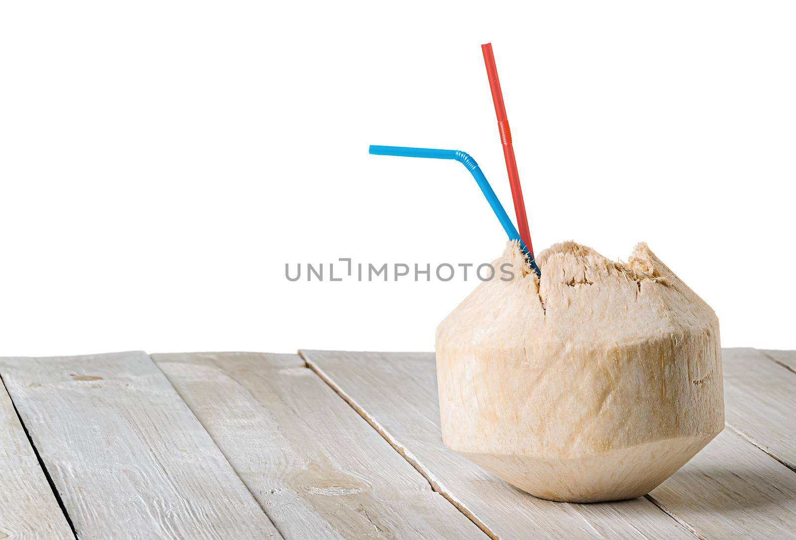 Young coconut on wooden table isolated on white by Cipariss