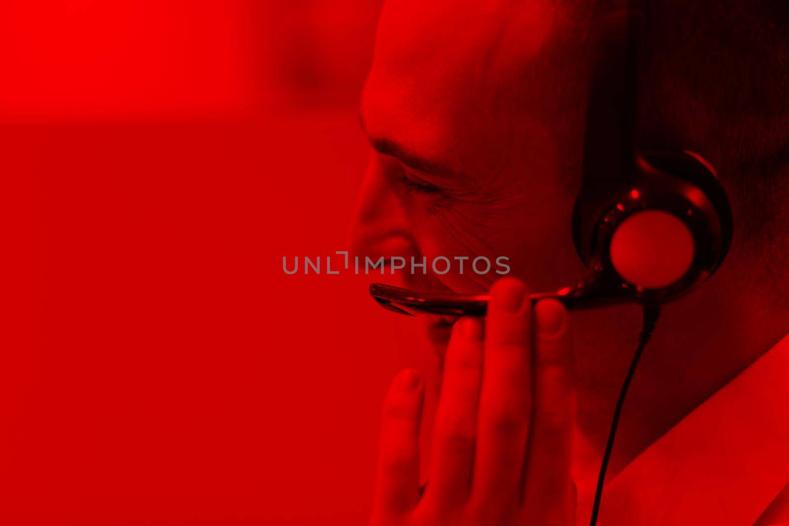 young smiling male call centre operator doing his job with a headset