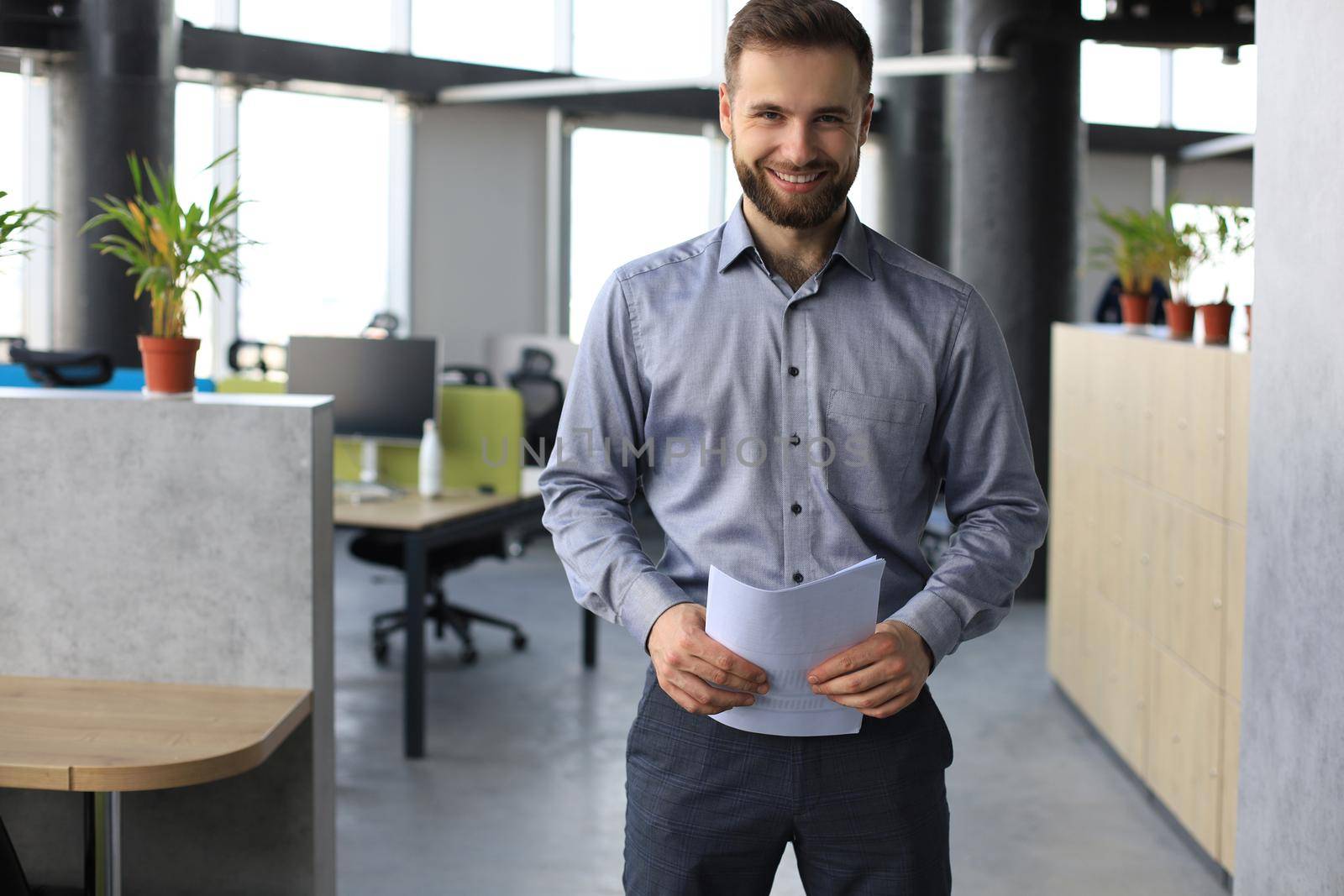 Young handsome businessman smiling in an office environment. by tsyhun