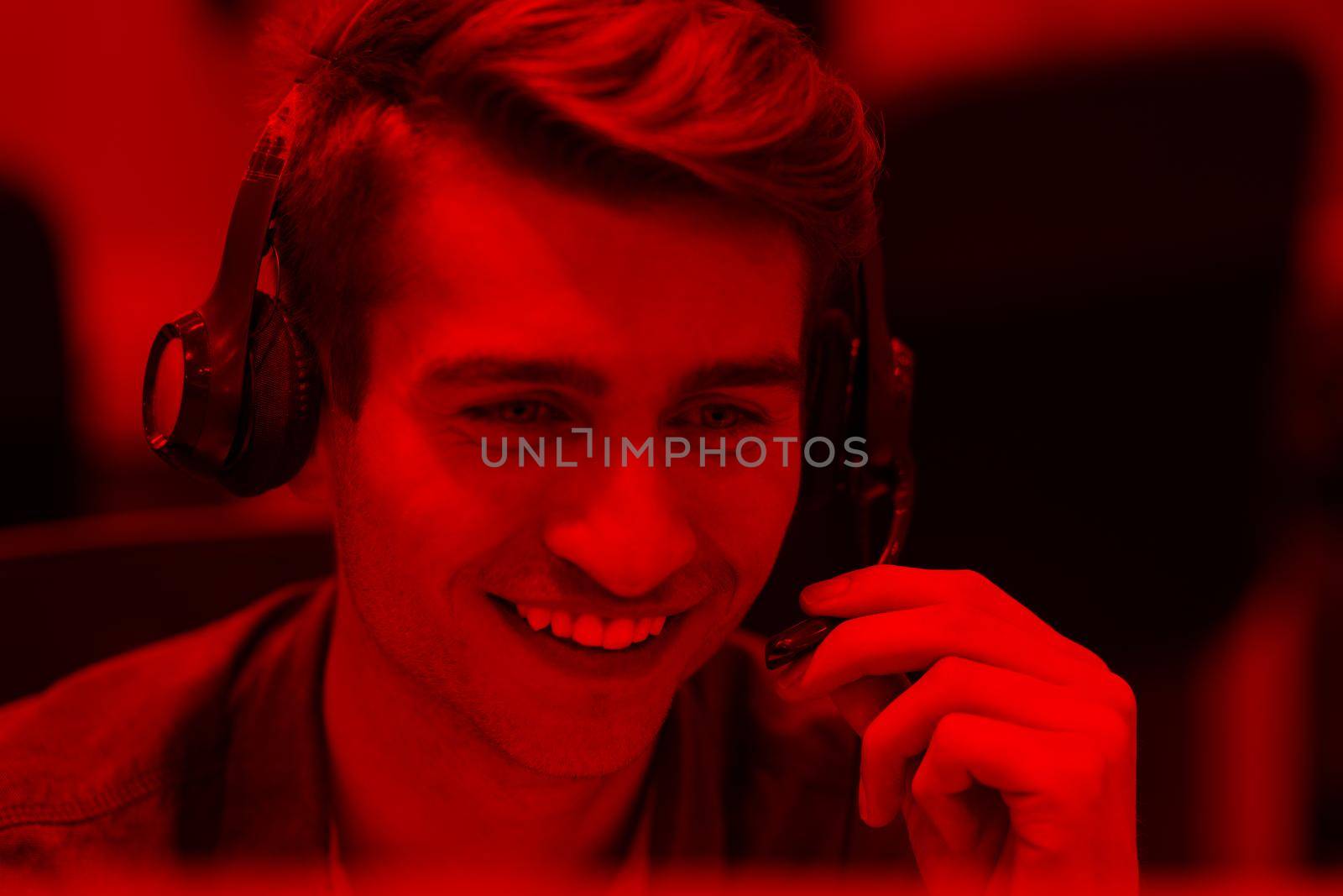 young smiling male call centre operator doing his job with a headset