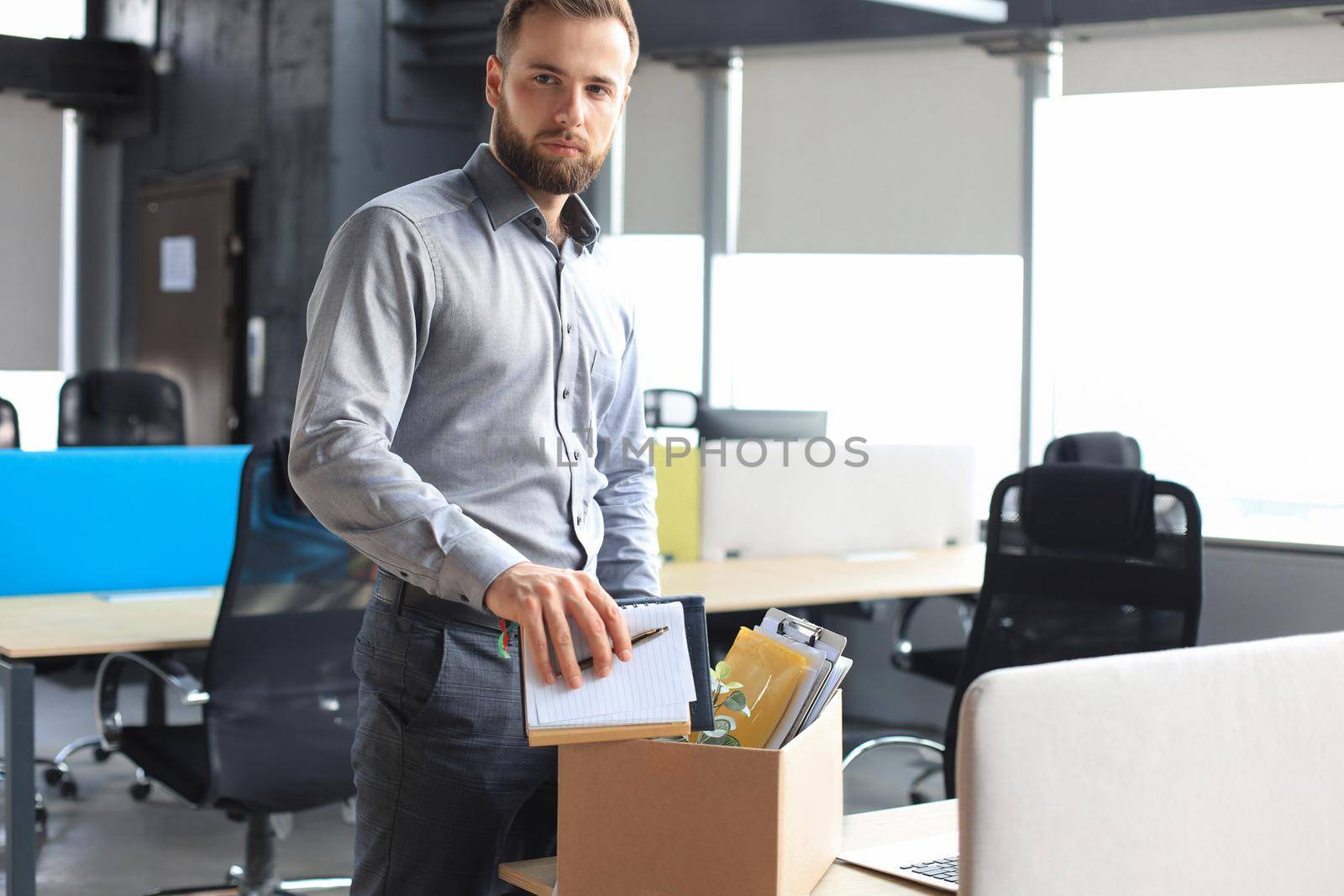 Sad dismissed worker are taking his office supplies with him from office