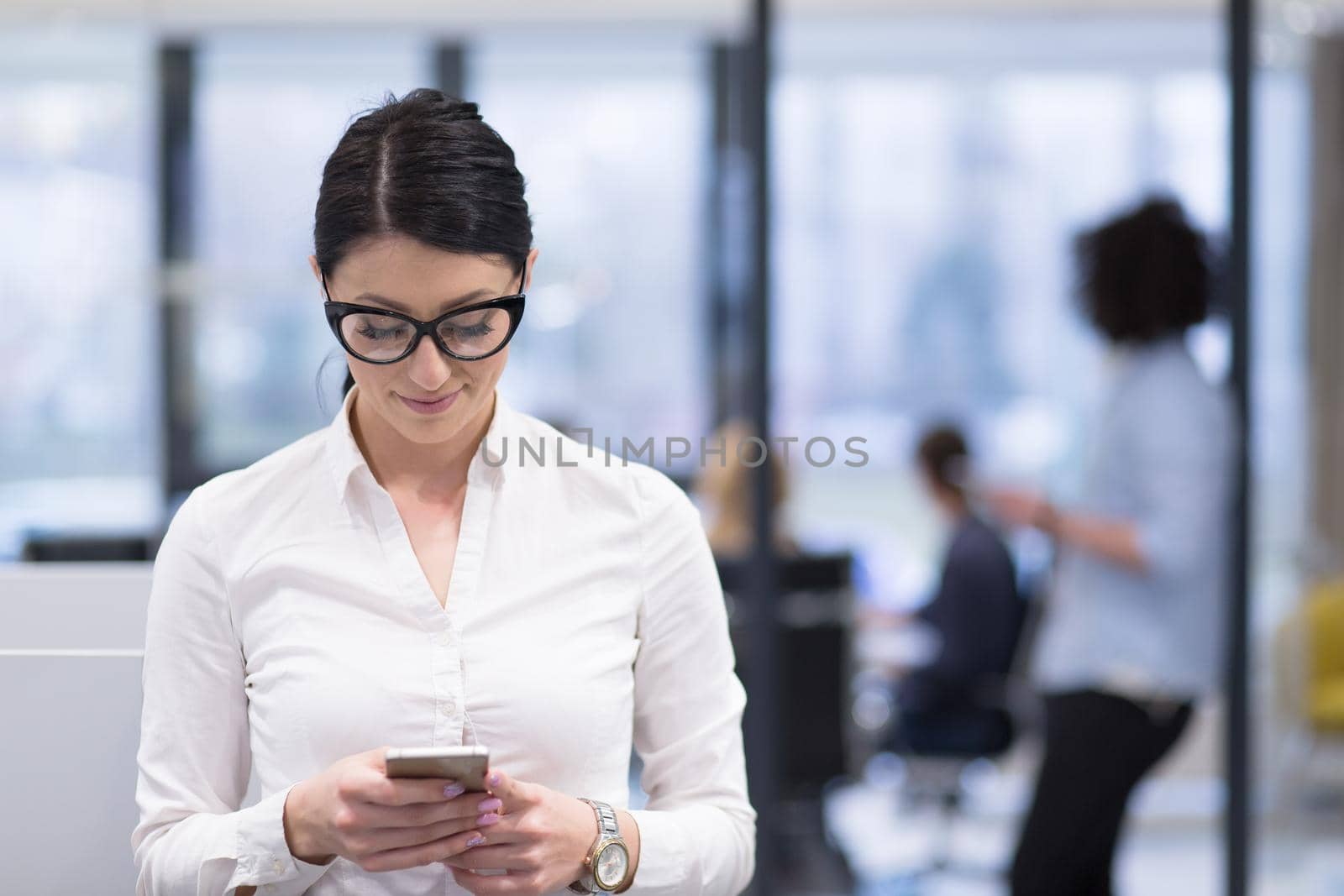 Elegant Woman Using Mobile Phone in startup office building by dotshock