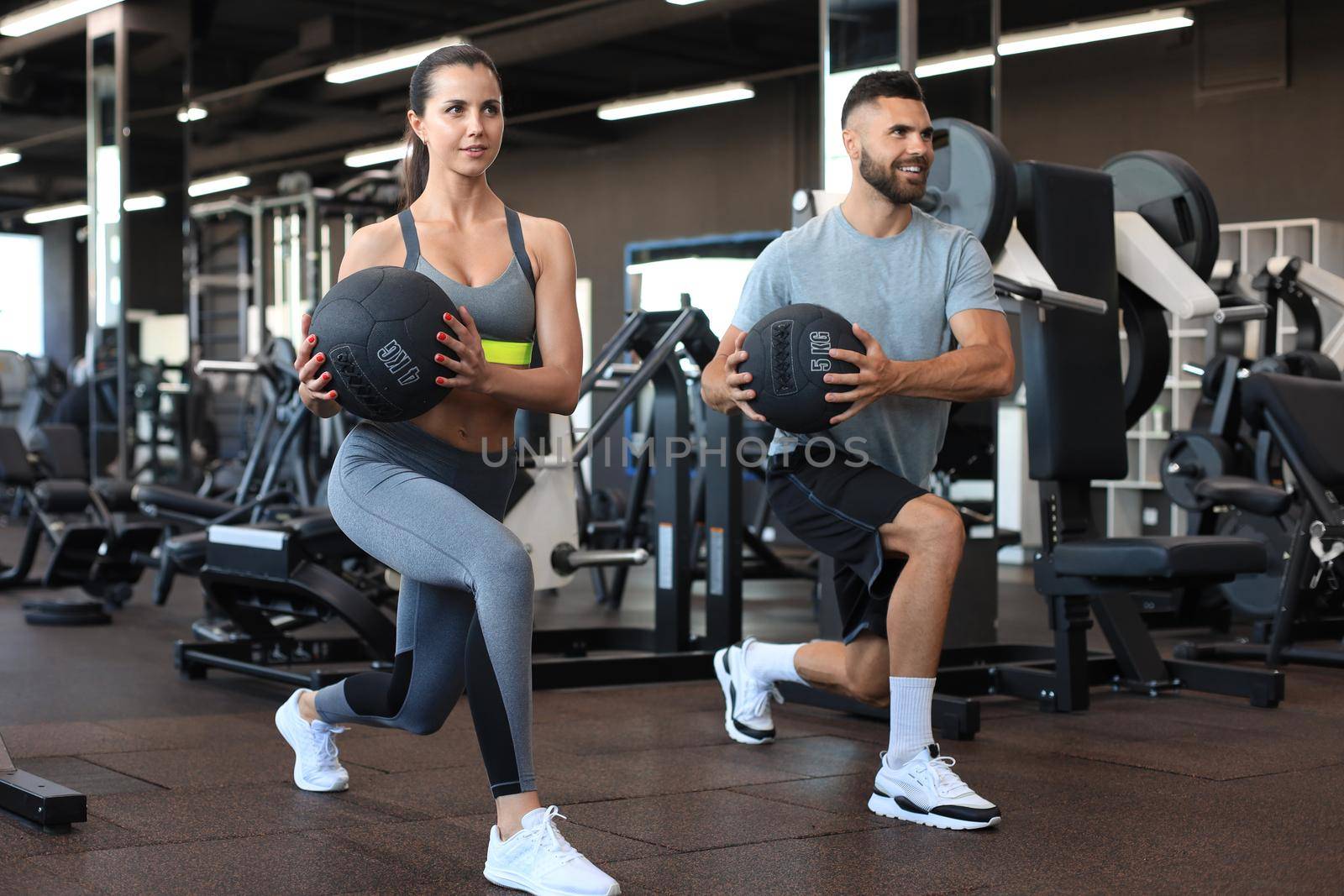 Attractive couple doing fitness with medcine ball at gym