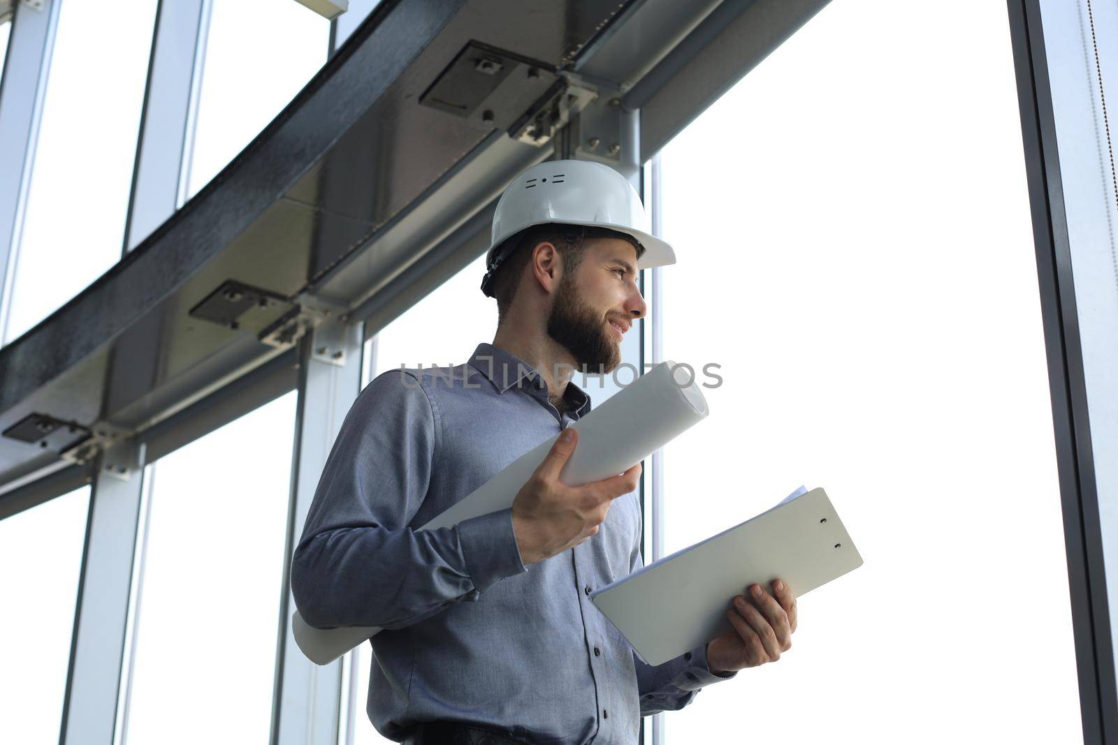 Shot of male architect wearing hardhat and inspecting new building